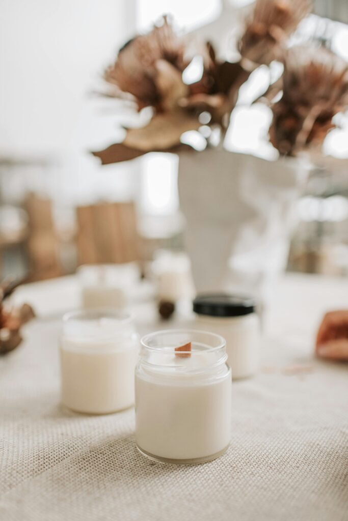 pexels photo 6755807 6755807 Close-up of handmade candles with wooden wicks in glass jars, showcasing artisan quality.